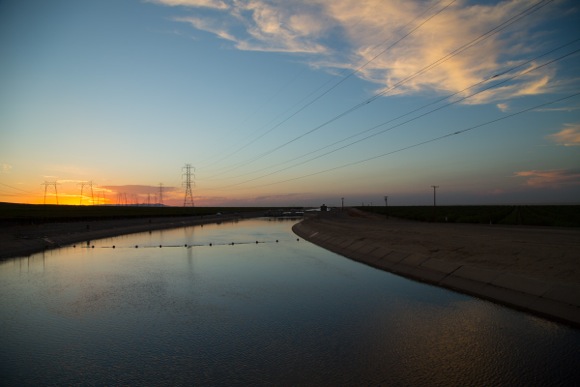 The sun sets behind power towers over the California Aqueduct near highway 41 in the Central Valley.